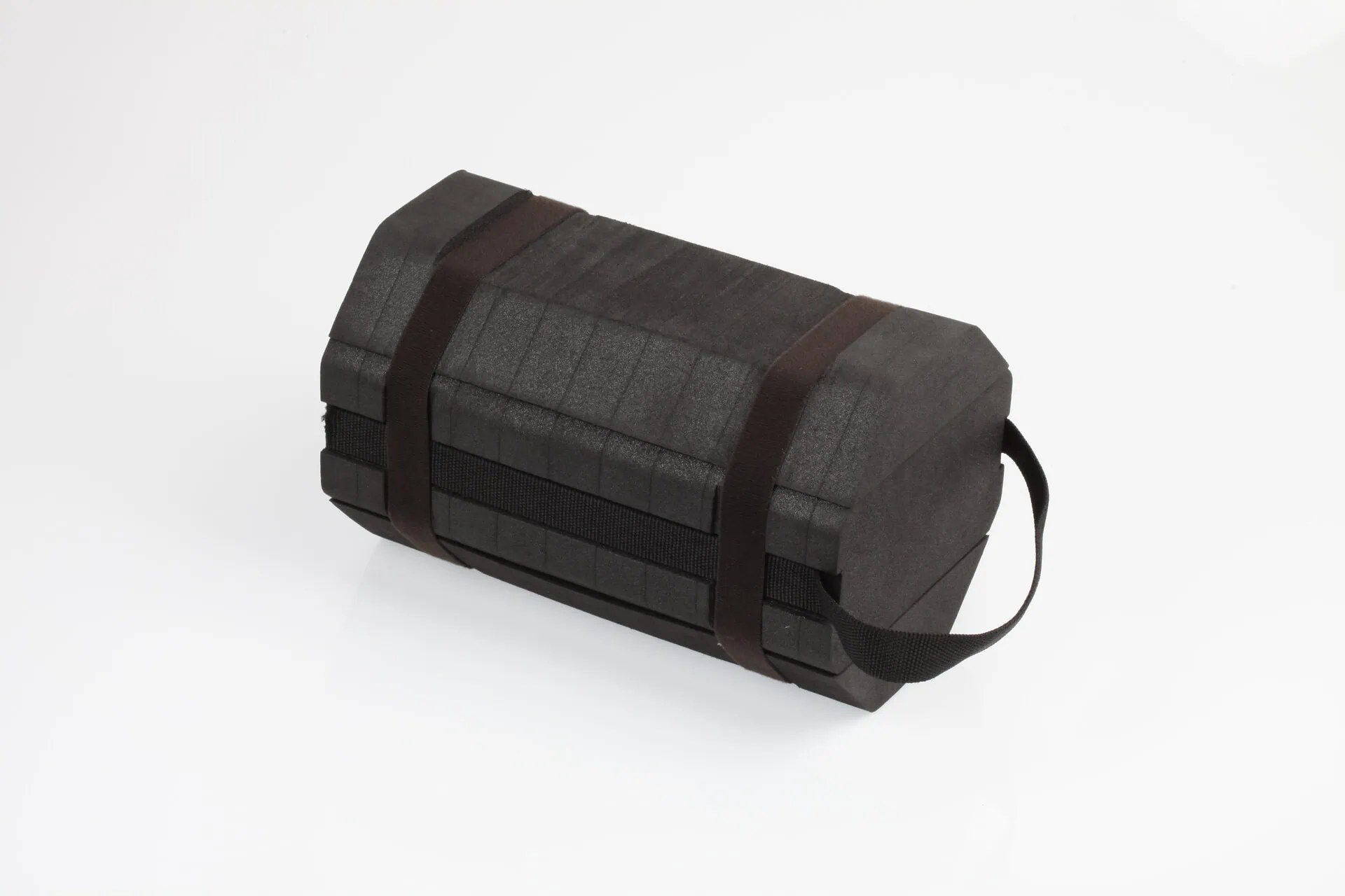 A rugged, hexagonal black case with a textured surface, secured with black straps and featuring a carrying handle, representing a portable repair kit for field use.