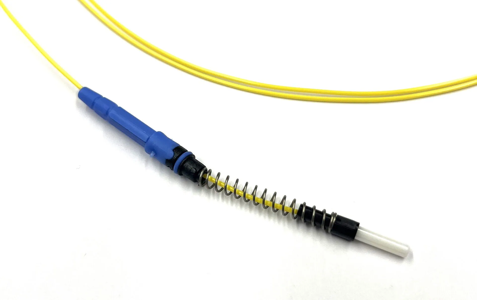 A detailed shot of a yellow fibre optic cable that ends in a blue connector with a black, coiled spring and a white ferrule, shown on a white background.