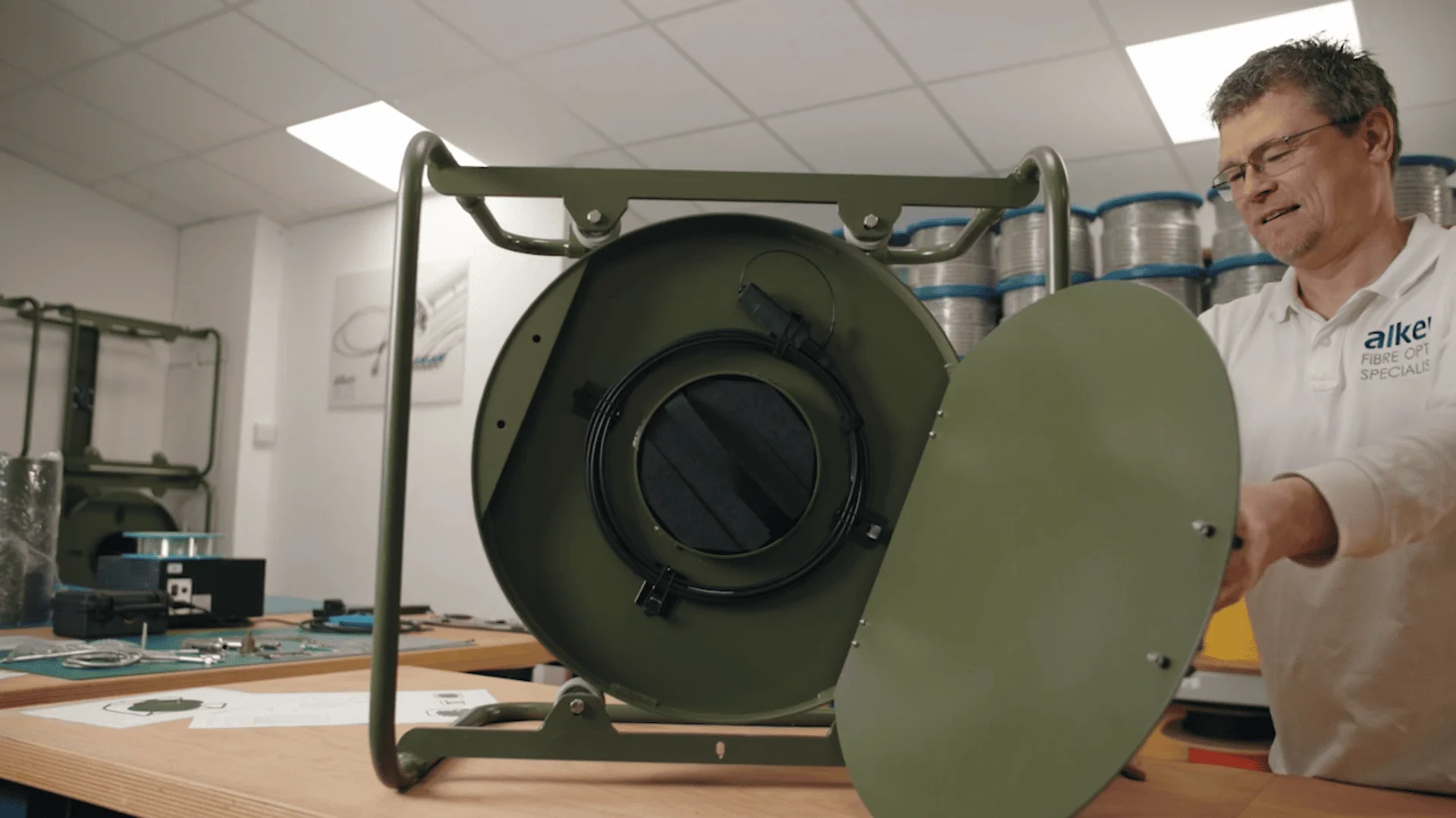 An extreme close-up view of a multi-core fibre optic cable end, showing six individual fibre cores arranged in a circular pattern within a metallic housing.